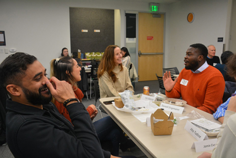 GrowFundMe Committee Group of people laughing and conversing at a box luncheon